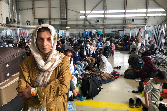 Afghan evacuees wait for the next flight to the U.S. in a fenced-in enclosure in a hangar at Ramstein Air Base in Germany. More than 25,000 Afghans have traveled through Ramstein to get to the United States.