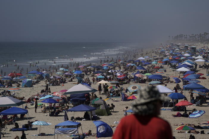 People crowd the beach in Huntington Beach, Calif., over the long Labor Day weekend last year, months before COVID-19 vaccines were available. This year, the CDC is recommending that people who are not fully vaccinated stay home.