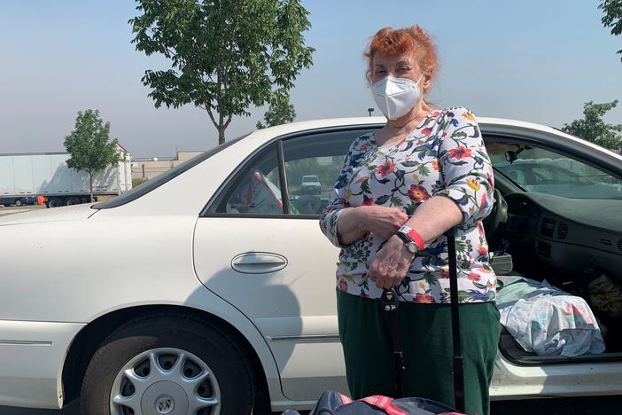 Mimi Routh, 79, unloads a suitcase from her car after evacuating from the Tahoe Senior Plaza to a shelter in nearby Gardnerville, Nev.