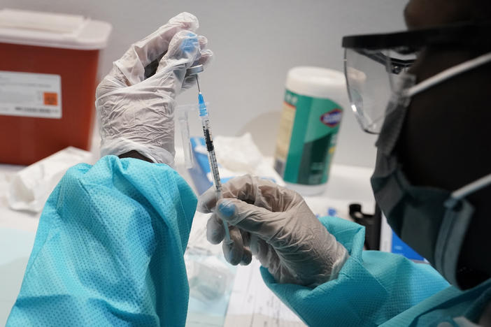 A health care worker fills a syringe with the Pfizer-BioNTech COVID-19 vaccine at the American Museum of Natural History in New York City this year.