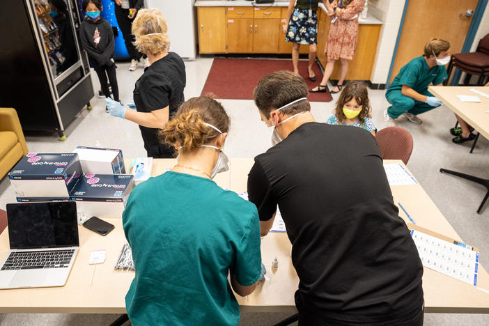 Nurses work at a COVID-19 testing day for students and school faculty at Brandeis Elementary School on in Louisville, Ky.