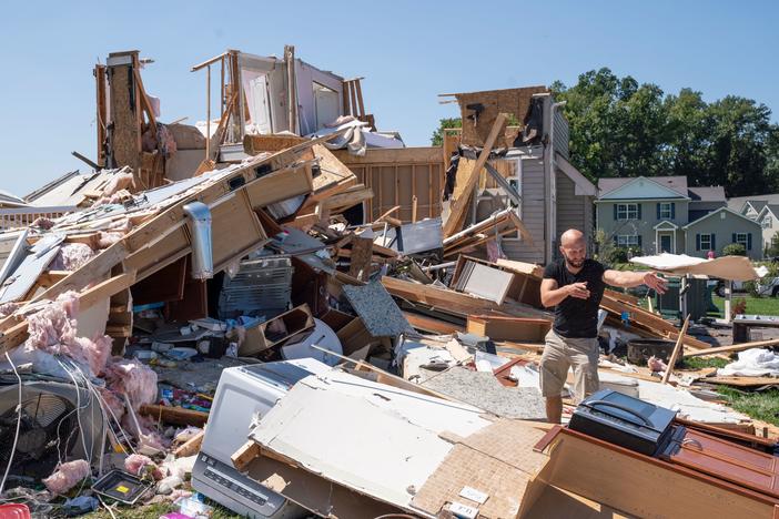 Sam Catrambone clears debris away from a friend's home that was damaged by a tornado in Mullica Hill, N.J., on Thursday after record-breaking rainfall brought by the remnants of Hurricane Ida that swept through the area.