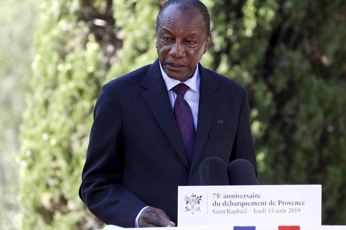 Witnesses say heavy gunfire has erupted near the presidential palace in Guinea's capital and went on for hours. It was not immediately known whether President Alpha Conde, seen above in August 2019, was home at the time the shooting began.