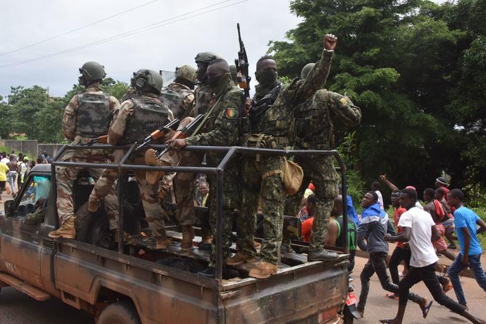 People celebrate in the streets with members of Guinea's armed forces after the arrest of Guinea's president, Alpha Conde, in a coup d'etat in Conakry on Sunday.