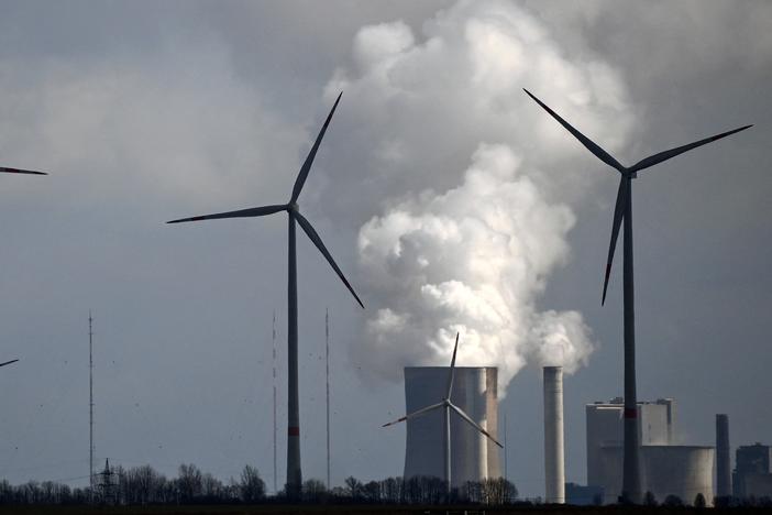 A new study finds that common climate change terms can be confusing to the public. That includes phrases that describe the transition from fossil fuels to cleaner sources of energy. Here, wind turbines operate near a coal-fired power plant in Germany.