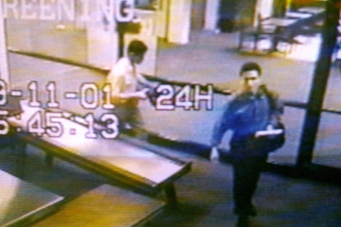 Two men identified by authorities as hijackers Mohamed Atta (right) and Abdulaziz Alomari (center) pass through airport security on Sept. 11, 2001, at Portland International Jetport in Maine in an image from airport surveillance tape released on Sept. 19, 2001.