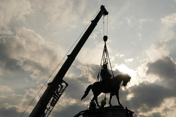 Crews work to remove one of the country's largest remaining monuments to the Confederacy, a towering statue of Confederate Gen. Robert E. Lee on Wednesday in Richmond, Va.