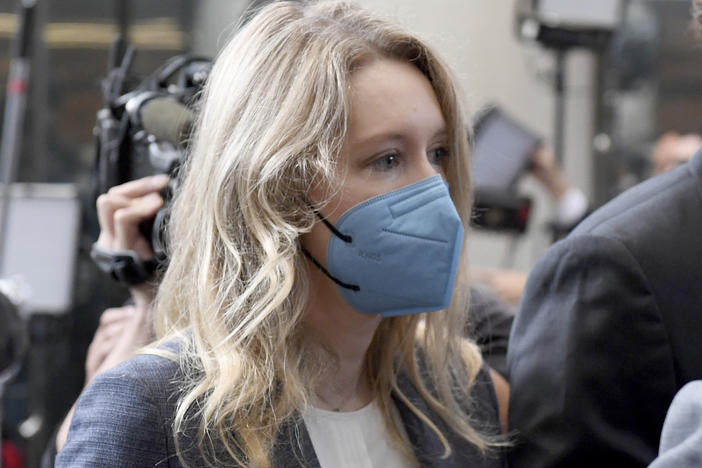 Elizabeth Holmes (center) walks into the federal courthouse for her trial in San Jose, Calif., on Wednesday.