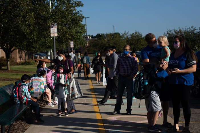Parents drop their children off for the first day of school in Novi, Mich., on Tuesday.