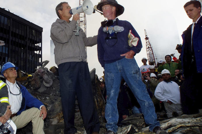 President George W. Bush stands in the rubble of the World Trade Center in New York and speaks to workers involved in the cleanup effort on Sept. 14, 2001.