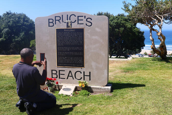 William Redmond III, a visitor from Atlanta, takes a photo of the historic plaque marking Bruce's Beach in April in Manhattan Beach, Calif.
