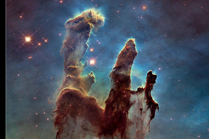 Two views of the Eagle Nebula's "Pillars of Creation," both taken by the Hubble Space Telescope. The left shows the pillars in visible light; the right image was taken in infrared light.