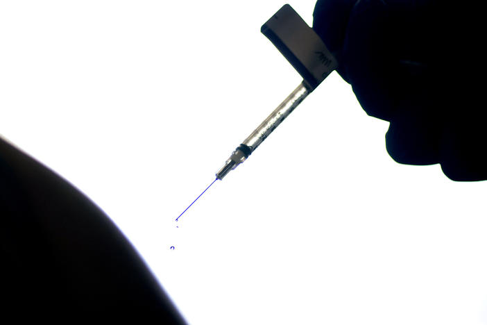 A droplet falls from a syringe after a health care worker was injected with the Pfizer COVID-19 vaccine last year at a hospital in Providence, R.I.