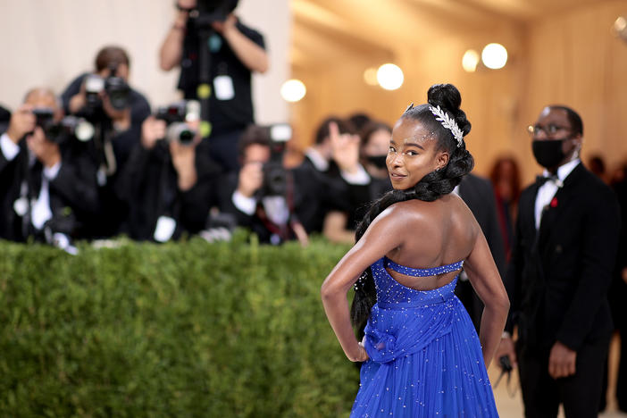 Co-chair Amanda Gorman dons a cobalt-blue Vera Wang gown and a book-shaped clutch that says "give us your tired," a look inspired by the Statue of Liberty.