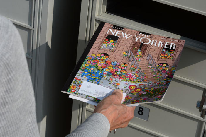 A woman retrieves a copy of <em>The New Yorker</em> magazine from her mailbox in Santa Fe, N.M., in 2020.
