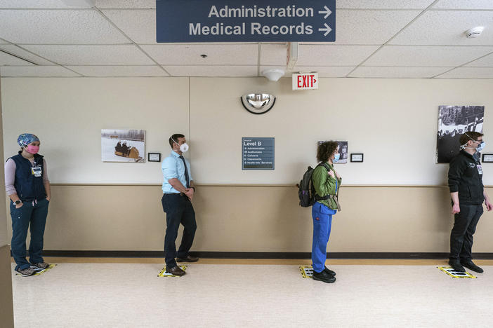 Front-line caregivers wait in line to receive a Pfizer-BioNtech COVID-19 vaccine in December at Providence Alaska Medical Center in Anchorage, Alaska.