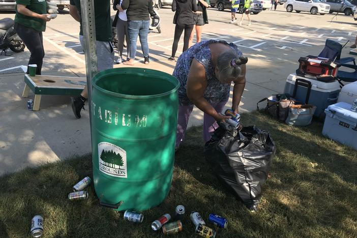 Holly Rutter collects cans from tailgaters on the campus of Michigan State University in East Lansing on Sept. 11, 2021. People in Michigan can get 10 cents for each can or bottle they return to a store.