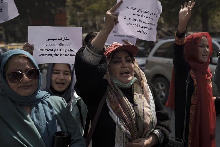 Women march to demand their rights under the Taliban rule during a demonstration near the former Women's Affairs Ministry building in Kabul, Afghanistan, on Sunday. The interim mayor of Afghanistan's capital said that many female city employees have been ordered to stay home by the country's new Taliban rulers.