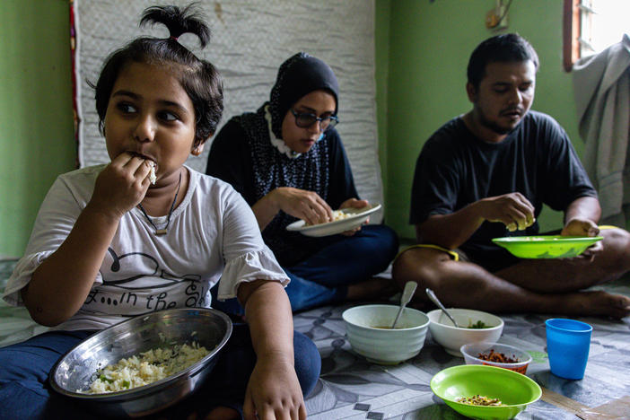Mohd Ali, right, of Selangor, Malaysia, lost his job due to the pandemic. The family's favorite foods — fried chicken, eggs, fruit and bread — are now typically out of reach. When they can afford chicken, they give most of it to their daughter, Hosna.