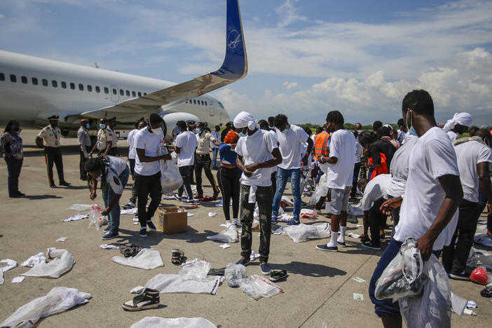 Haitians deported from the U.S. recover their belongings scattered on the tarmac of the Toussaint Louverture International Airport on Tuesday in Port-au-Prince, Haiti.