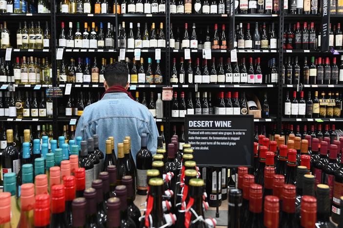 A patron stands in front of a shelf of wine bottles at The Liquor Store.Com in Brooklyn, N.Y., last March.