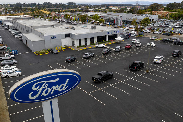 Vehicles sit in a nearly empty lot at a car dealership in Richmond, Calif., on July 1. The global semiconductor shortage has hobbled auto production worldwide, making it difficult to find a car to buy.