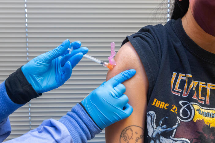 A health care worker administers a COVID-19 vaccine to a resident at the Jordan Valley Community Health Center in Springfield, Mo., in June.