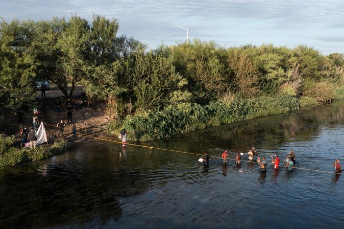 Haitian migrants cross the Rio Grande on Wednesday to get food and water in Mexico, as seen from Ciudad Acuña, Mexico. The U.S. is allowing some migrants to enter the country and sending others back to Haiti.