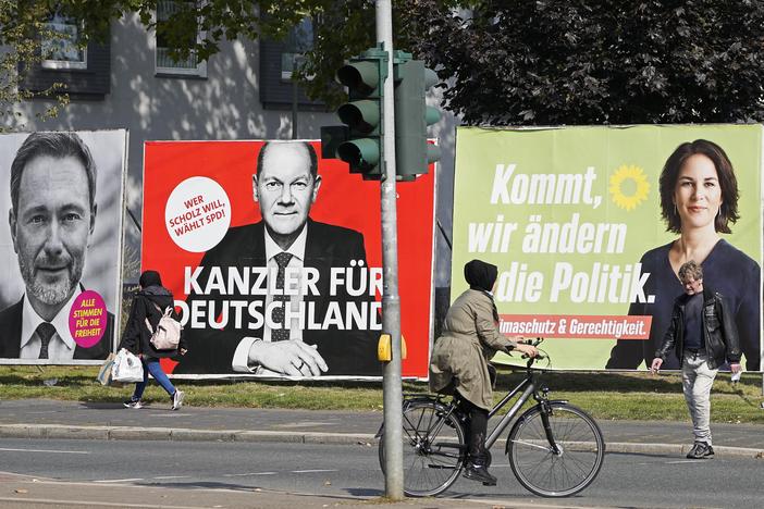 On Thursday, people in Gelsenkirchen, Germany, pass election posters of chancellor candidates Armin Laschet (from right) of the Christian Democratic Union, Annalena Baerbock of the Greens, Olaf Scholz of the Social Democratic Party and Christian Lindner of the Free Democratic Party.