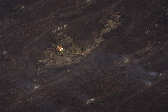 Lava from a volcanic eruption surrounds a house on the island of La Palma in the Canary Islands on Thursday.