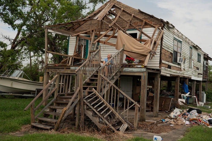 Annie Parfait, a Houma Nation elder, sits outside her home in Dulac, La., on Sept. 21, three weeks after Hurricane Ida made landfall in southeast Louisiana. Parfait, 70, rode out the storm at the Houma Nation Headquarters in Houma, La.