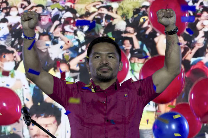 In this photo provided by the Manny Pacquiao MediaComms, Senator Manny Pacquiao raises his hands during a national convention of his PDP-Laban party in Quezon city, Philippines on Sunday Sept. 19, 2021. Philippine boxing icon and senator Manny Pacquiao says he will run for president in the 2022 elections.