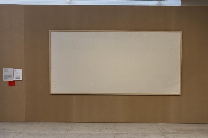 Jens Haaning's artwork "Take the Money and Run" is seen in the Kunsten Musem of Modern Art. The empty canvas was meant to hold thousands of dollars in cash — but the artist chose to hang on to the money.