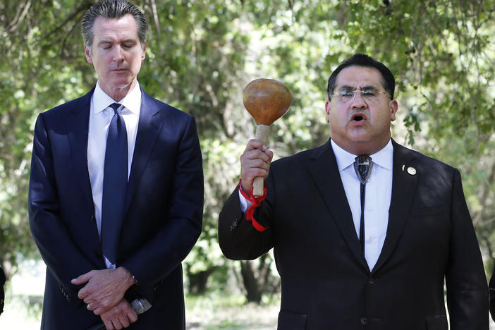 Gov. Gavin Newsom, left, bows his head as Assemblyman James Ramos opens a meeting with tribal leaders from around the state in 2019 in West Sacramento, Calif. In 2021, Ramos authored, and Newsom signed, a law to erect a monument to Native Americans in Sacramento outside the state capitol.