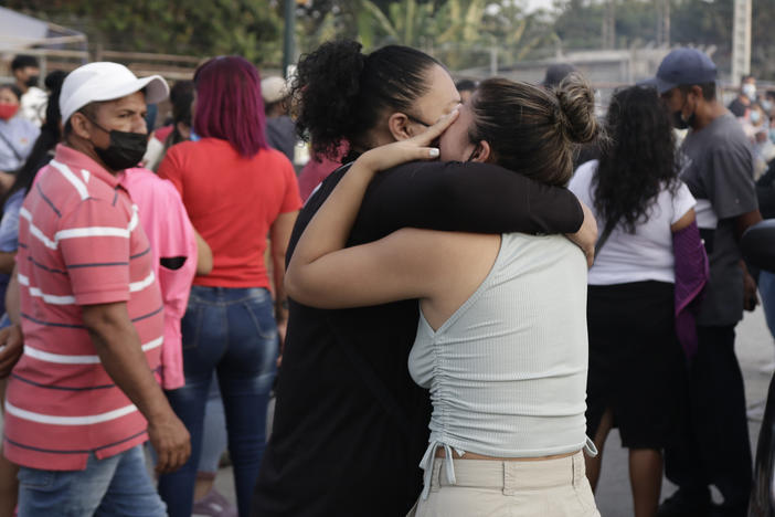 Women hug while waiting for some information about their relatives who are inmates at Litoral Penitentiary, after a prison riot, in Guayaquil, Ecuador, Wednesday. The authorities report at least 100 dead and 52 injured in the riot which began Tuesday at the prison.