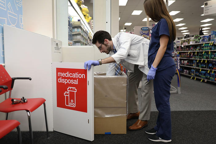 CVS Pharmacist Raphael Lynne (left), D., MBA, and Stephanie Garcia, a Pharmacy tech., check the medication disposal box where people can drop off their expired, unused or unwanted medications for safe disposal.