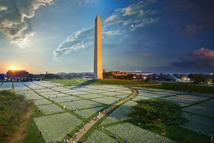 A composite photograph captures the passage of day to night at the "In America: Remember" art installation on the National Mall in Washington, D.C. Each flag represents an American life lost to COVID-19.
