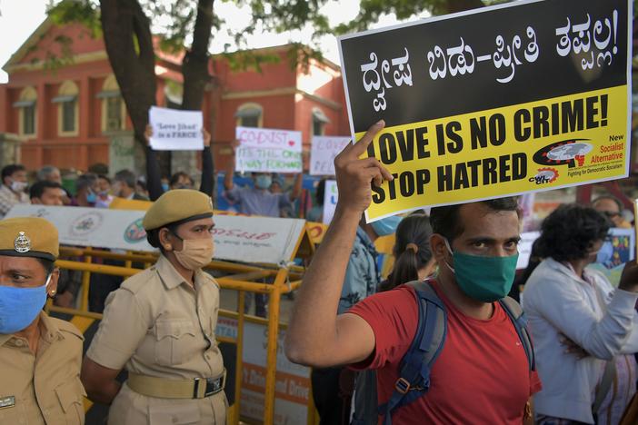 A civil rights activist holds a placard during a 2020 demonstration in Bengaluru, India, condemning the proposal in several states of laws against so-called "love jihad." That's an unfounded conspiracy theory spread by Hindu nationalists who accuse Muslim men of wooing Hindu women in order to force them to convert to Islam.