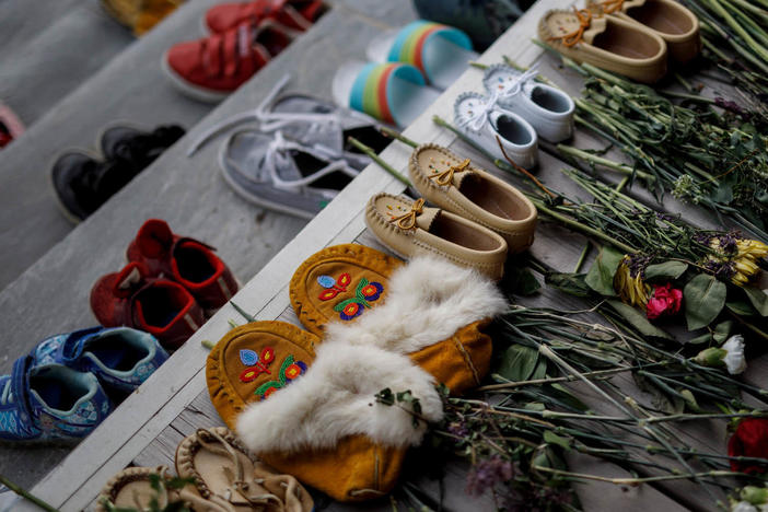 Flowers, shoes and moccasins sit on the steps of the main entrance of the former Mohawk Institute, which was a residential school for Indigenous kids, in Brantford, Ontario. The memorial is to honor the children whose remains were discovered in unmarked graves in recent months in Canada.