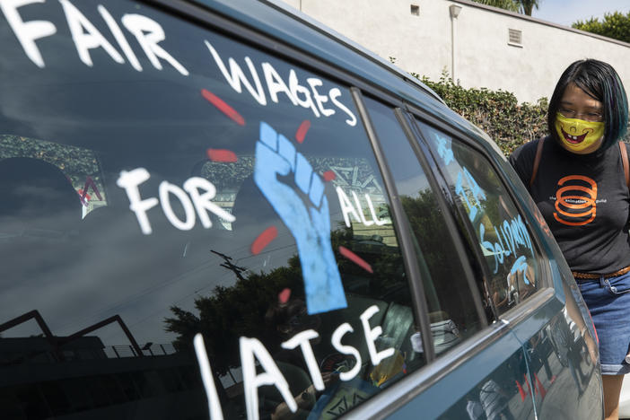 Crystal Kan, a storyboard artist, draws signs on cars of IATSE union members during a rally in Los Angeles in September.