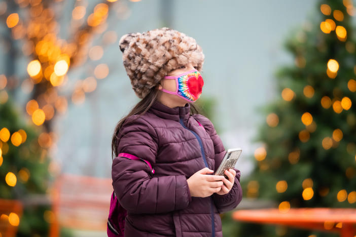 Above, a child walks by a Christmas display in New York City last year. Dr. Anthony Fauci, the nation's top infectious disease expert, says it's "too soon to tell" whether Americans will be able to gather during the winter holidays.
