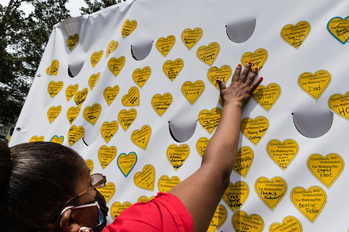 COVID-19 survivors gather in New York and place stickers representing lost relatives on a wall in remembrance of those who have died during the pandemic.