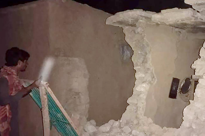 A local resident looks at his damaged house following a severe earthquake that hit the area in Harnai, about 60 miles from Quetta, Pakistan. A powerful earthquake shook parts of southwestern Pakistan early Thursday.