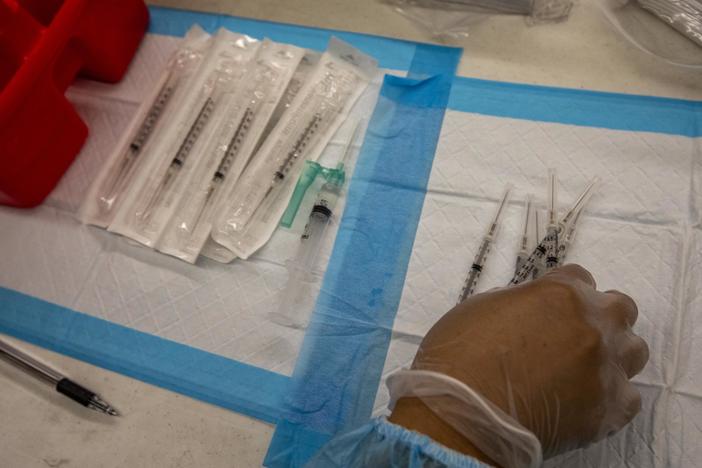 A healthcare worker prepares doses of the Pfizer-BioNTech Covid-19 vaccine at a mobile vaccination clinic at a high school in Los Angeles in August.