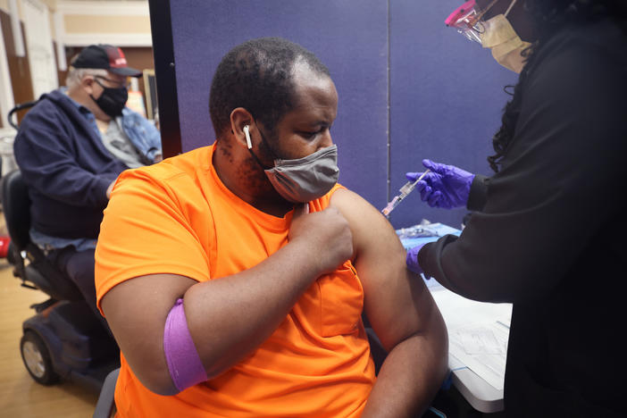 Gloria Clemons gives a COVID-19 vaccine to Navy veteran Perry Johnson at the Edward Hines, Jr. VA Hospital in Hines, Ill., in September.