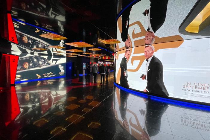 Advertisements in a theater in London's Leicester Square show Daniel Craig as James Bond in <em>No Time to Die.</em> Ahead of its opening in the U.S. this weekend, the film had taken in more than $120 million in 54 foreign markets.