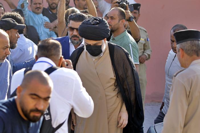Populist Shiite cleric Muqtada al-Sadr, center, arrives to a polling center to vote in the parliamentary elections in Najaf, Iraq, on Sunday.
