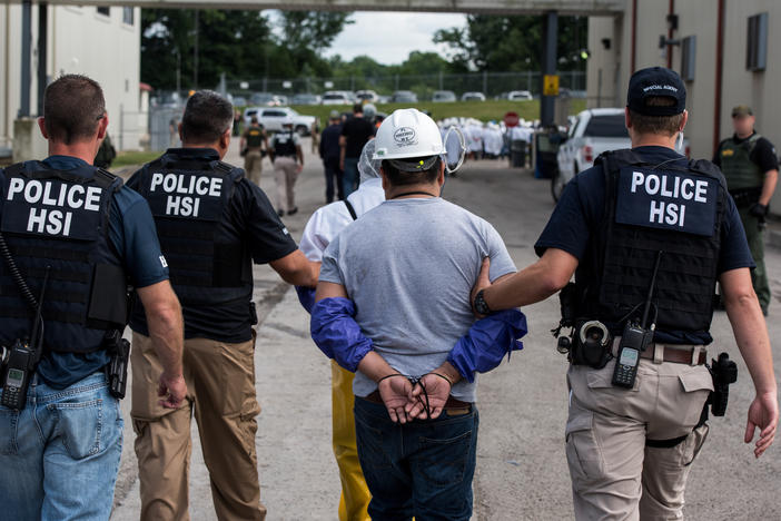 "We will not tolerate unscrupulous employers who exploit unauthorized workers," Homeland Security Secretary Alejandro Mayorkas said, as he ordered a halt to mass workplace raids. Here, special agents with Homeland Security Investigations lead a worker away from a workplace raid in Ohio in 2018, part of a string of such operations during the Trump administration.