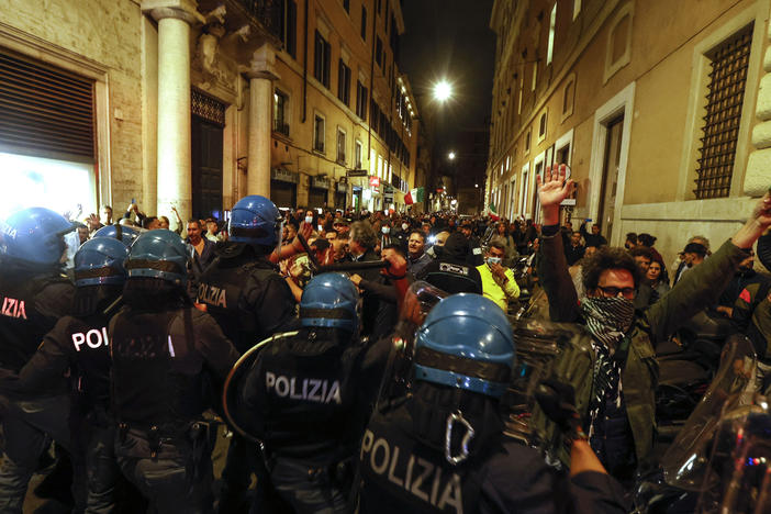 Anti-riot police officers face demonstrators trying to reach the Chigi Palace government office in Rome during a protest Saturday against green pass.