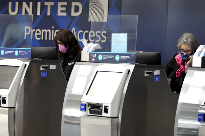 In this Oct. 14, 2020 file photo, United Airlines employees work at ticket counters in Terminal 1 at O'Hare International Airport in Chicago.
